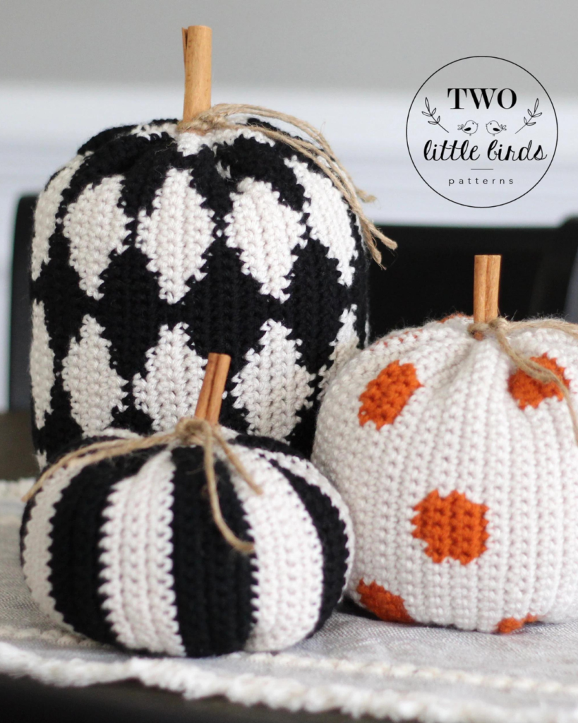 three crochet pumpkins of varying sizes, shapes, and colors