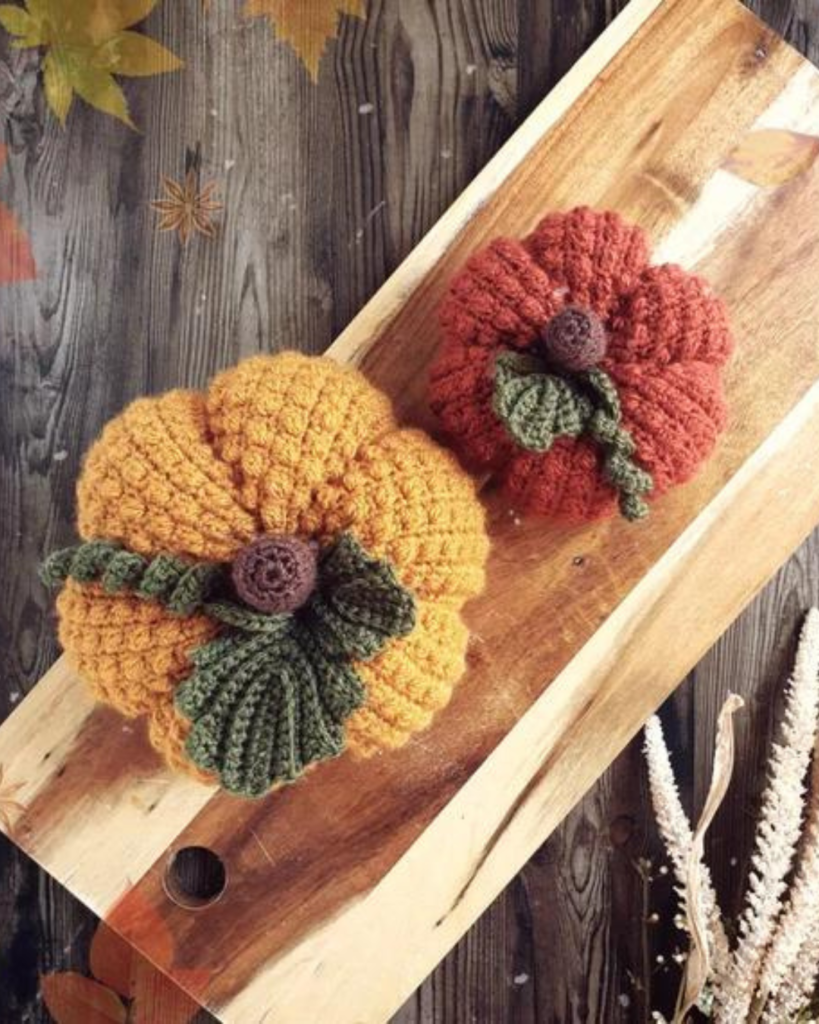 two pumpkins of varying size and color