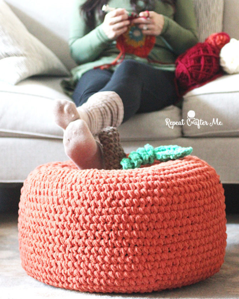 woman resting feet on pumpkin plush