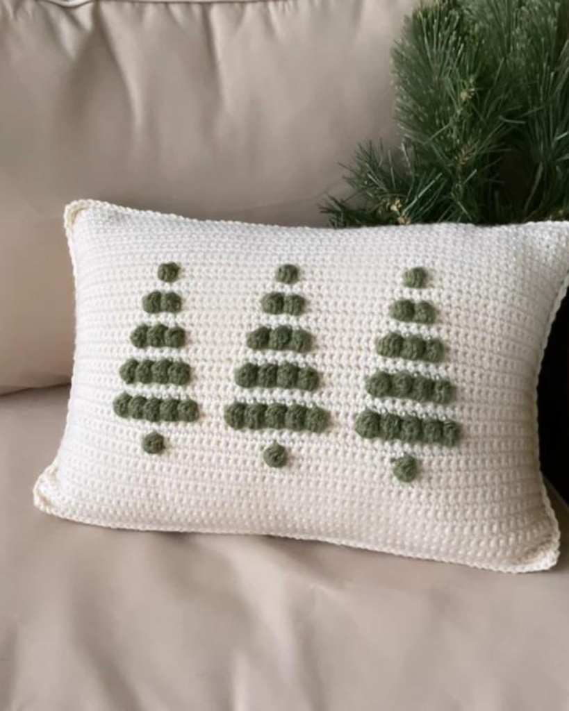 white crochet pillow with three green bobble stitch trees