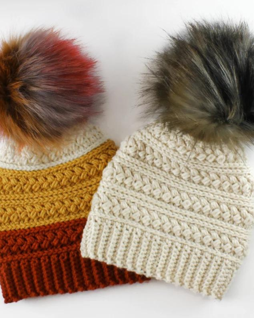 two crochet hats with pom poms