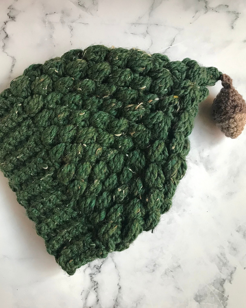 green puff stitch beanie with acorn amigurumi