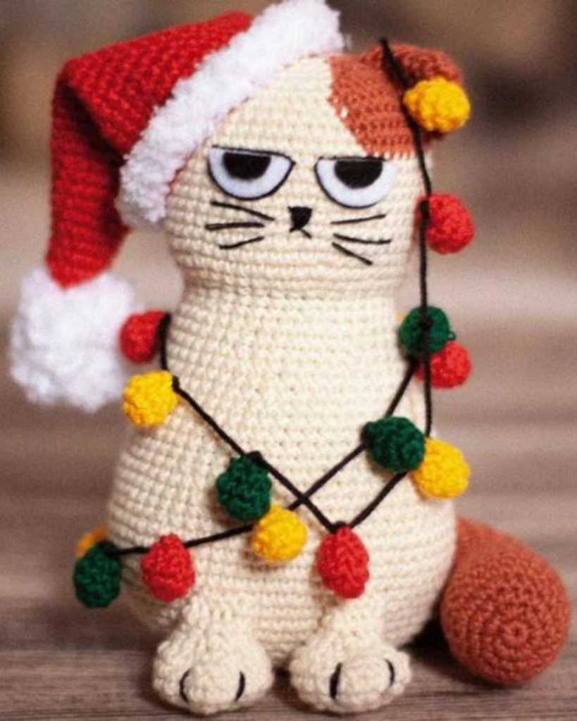 crochet amigurumi grumpy cat with crochet santa hat and christmas lights