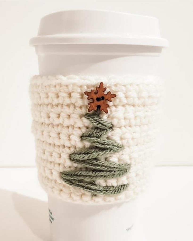 white crochet travel mug cozy with green christmas tree and star button
