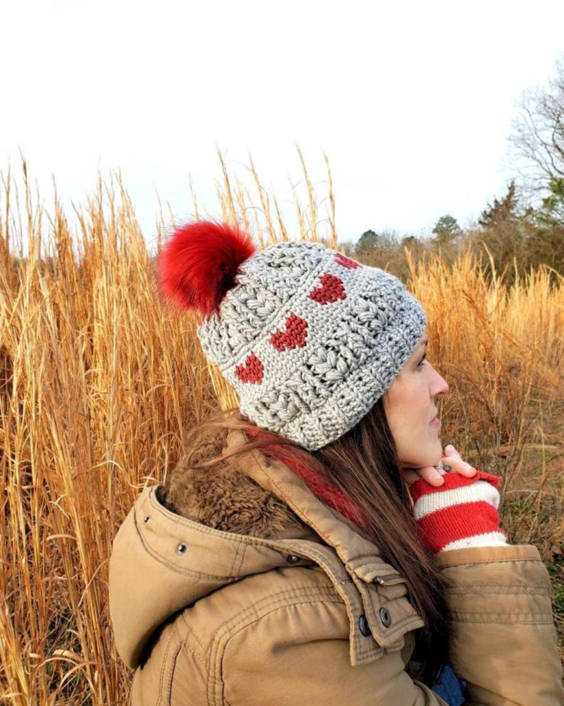 grey crochet beanie with red pom pom and hearts