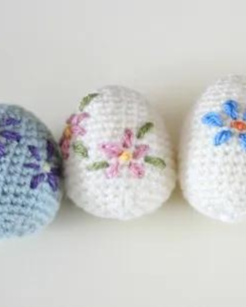 three crochet eggs with embroidered flowers
