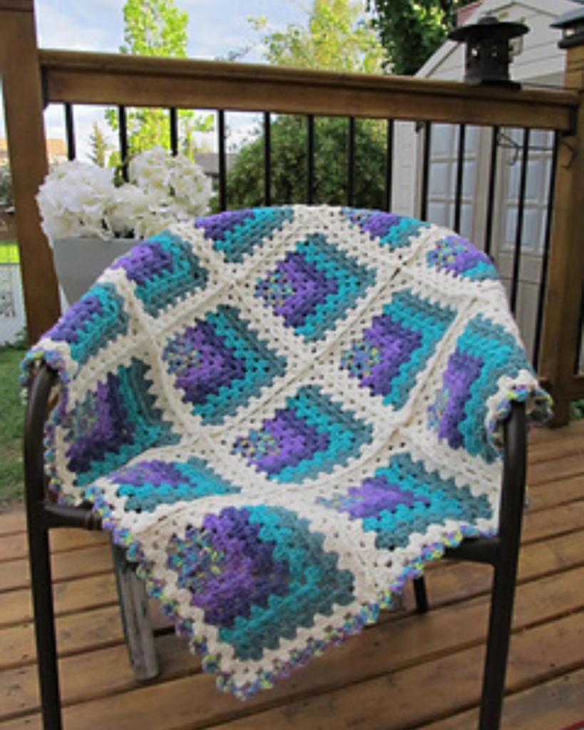 blue, purple, and white crochet blanket with mitered granny squares