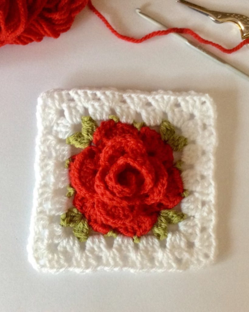 white crochet granny square with red rose