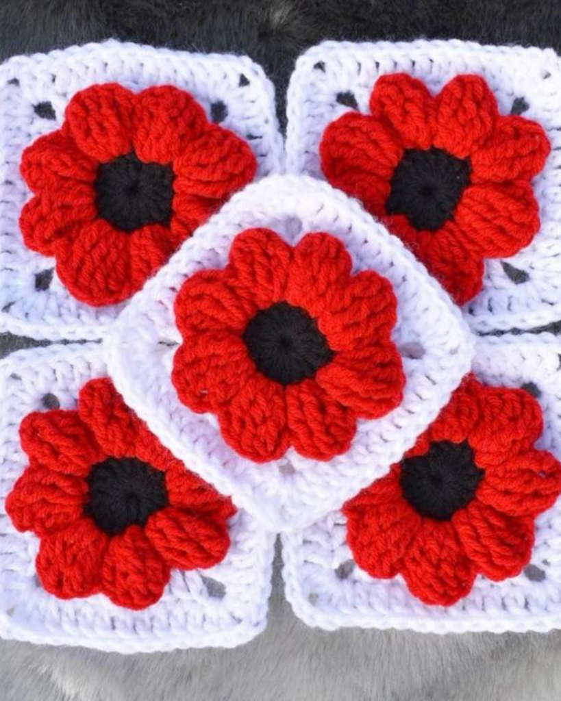 white crochet granny squares with red and black poppy flowers