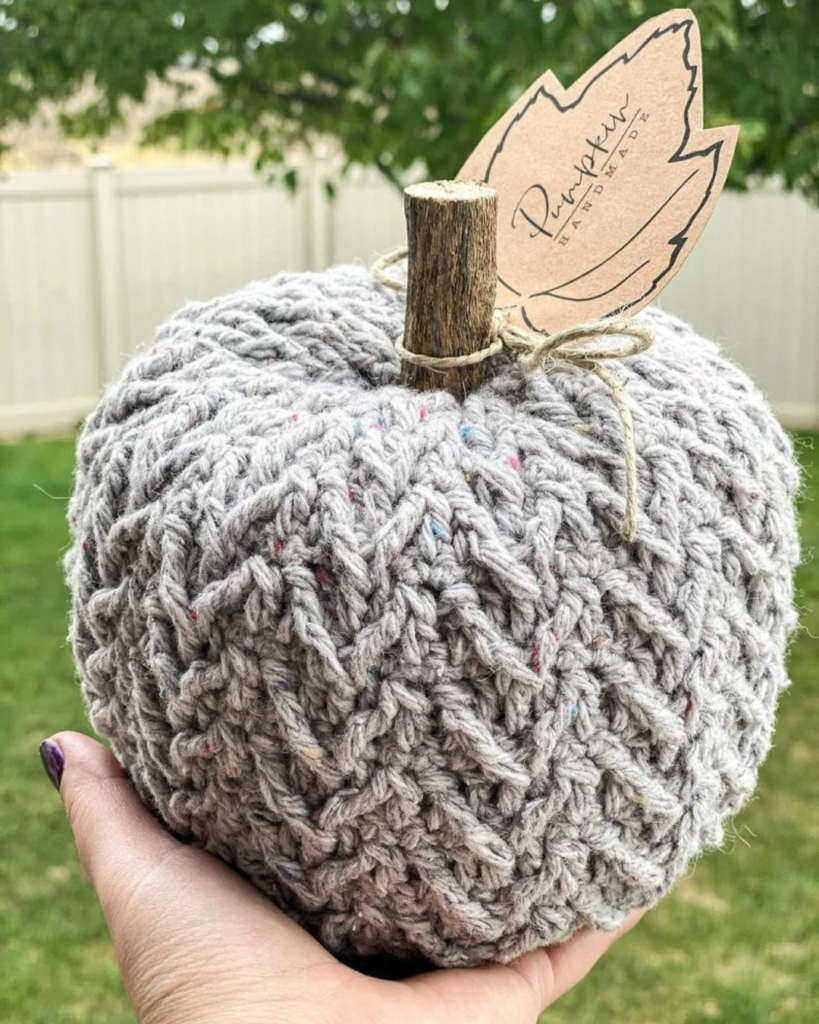 hand holding grey textured crochet pumpkin