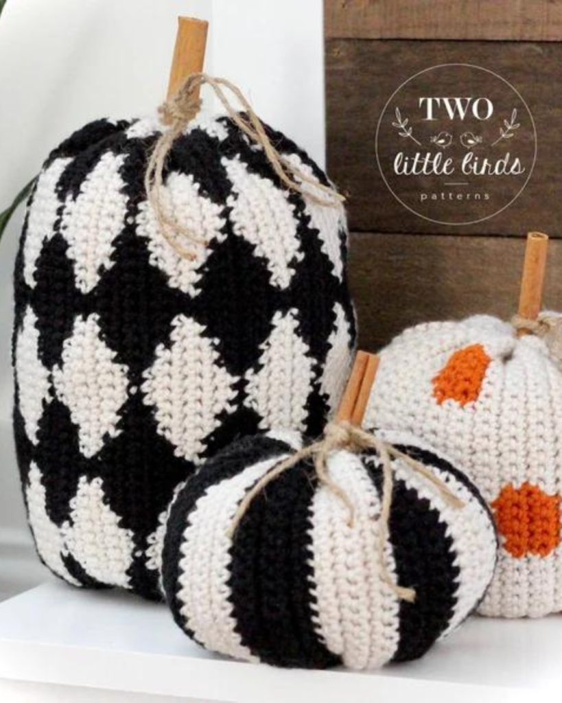 three crochet pumpkins of varying size, color, and pattern