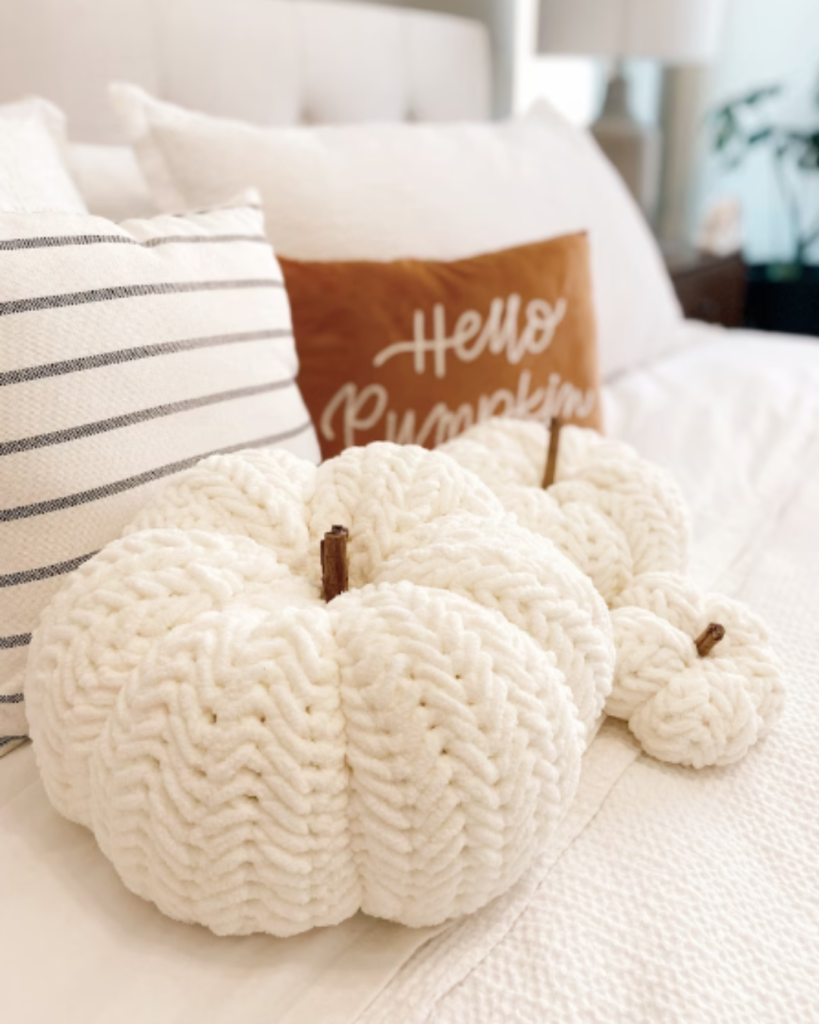 three white textured crochet pumpkins of varying size