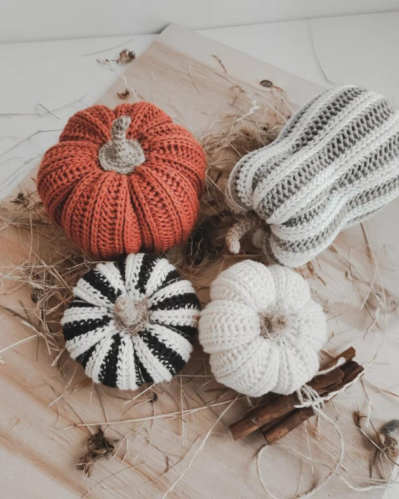 four crochet fall pumpkins of varying size, color, and texture