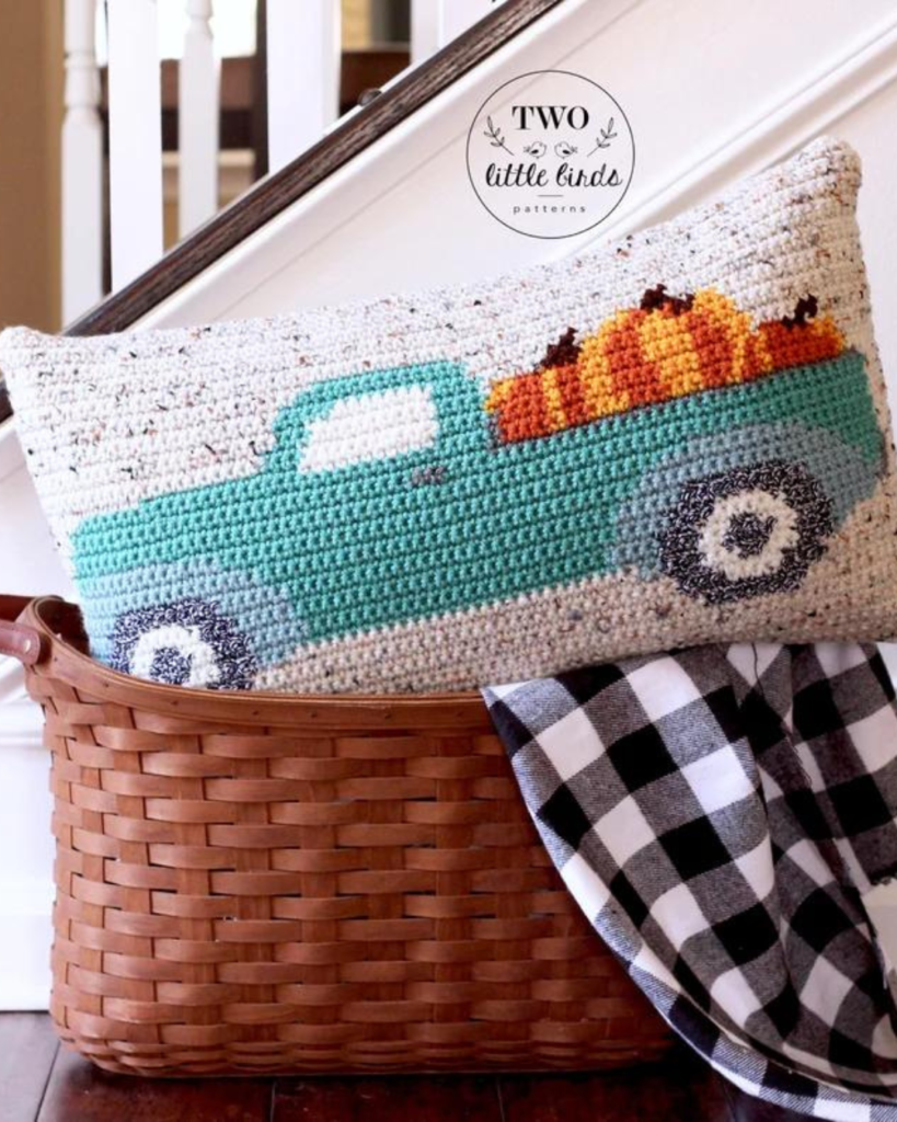 crochet pillow of a truck with pumpkins in it