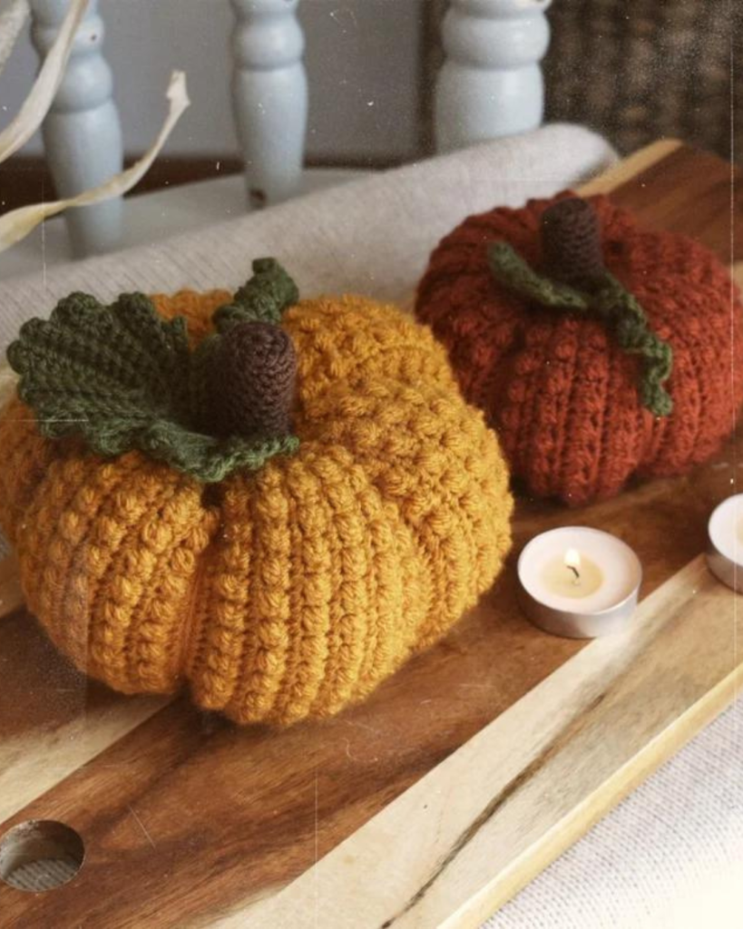 two crochet pumpkins of varying color and size