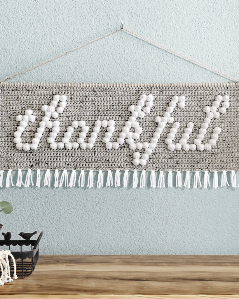 crochet bobble stitch wallhanging that says "thankful"