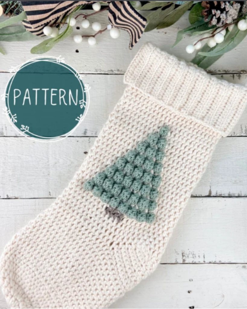 white crochet christmas stocking with green bobble stitch tree