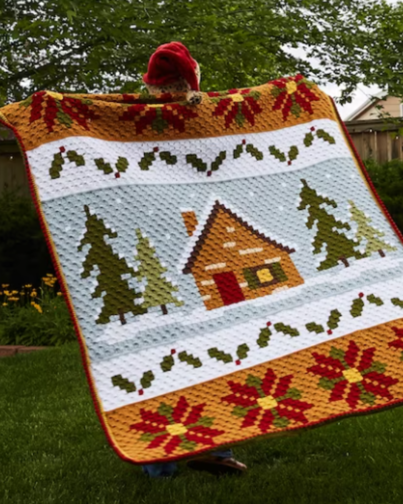 corner to corner crochet with poinsettias, holly, trees, and a cottage with snow