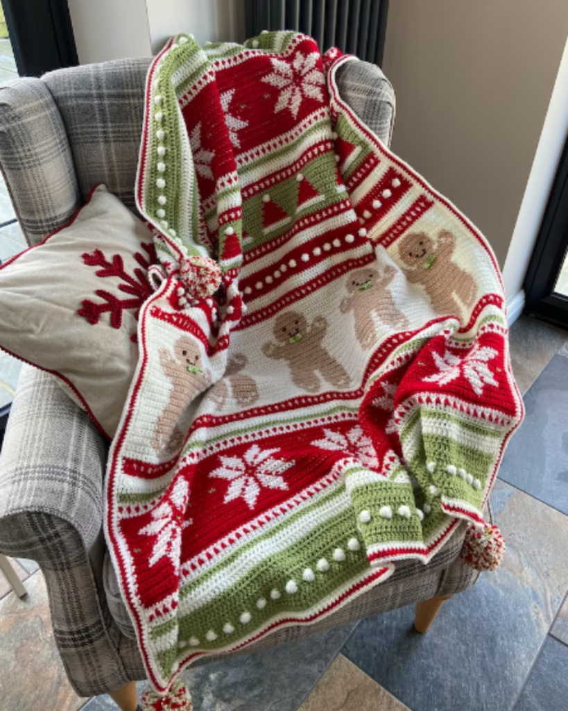 red, green, and white striped blanket with snowflakes, santa hats, and gingerbread men