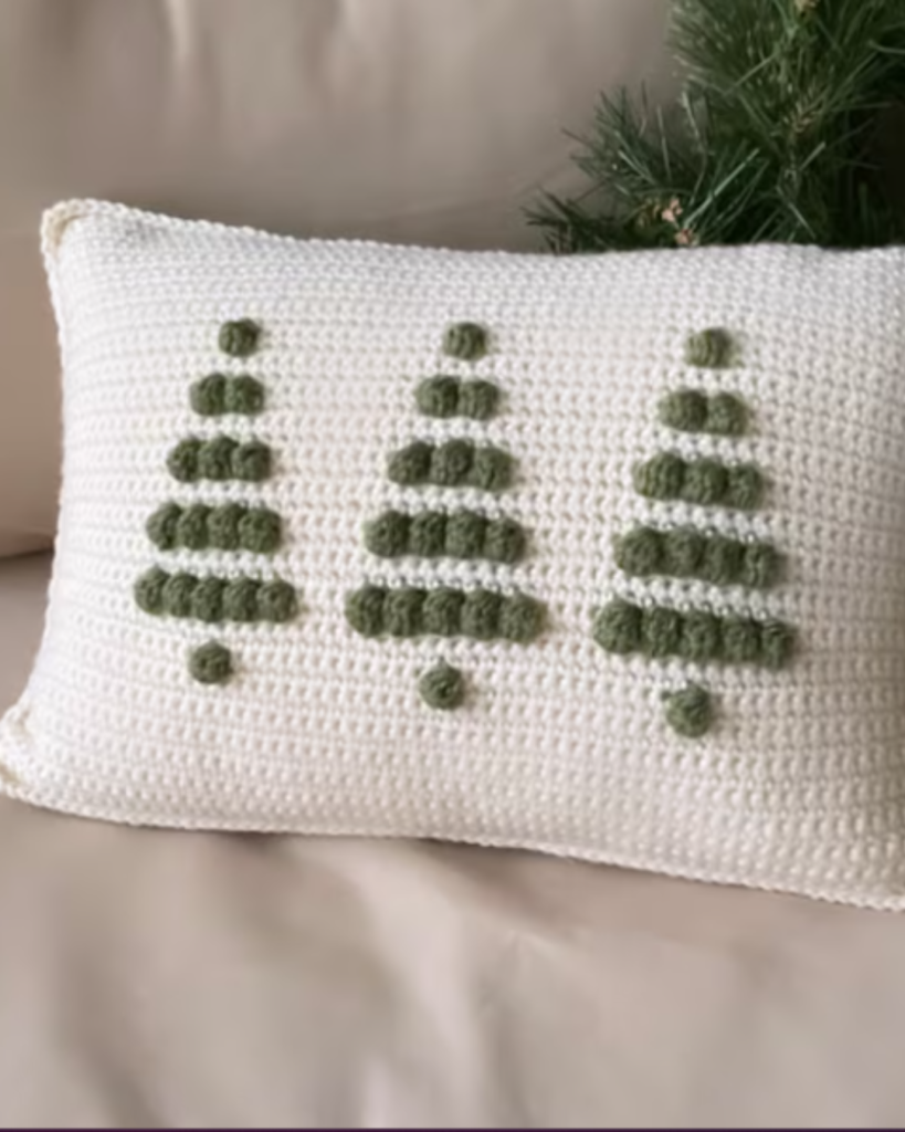 white crochet pillow with three green bobble trees