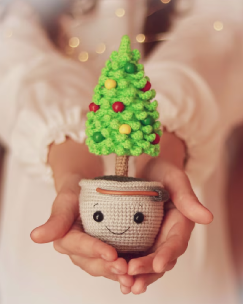 hands holding happy crochet christmas tree