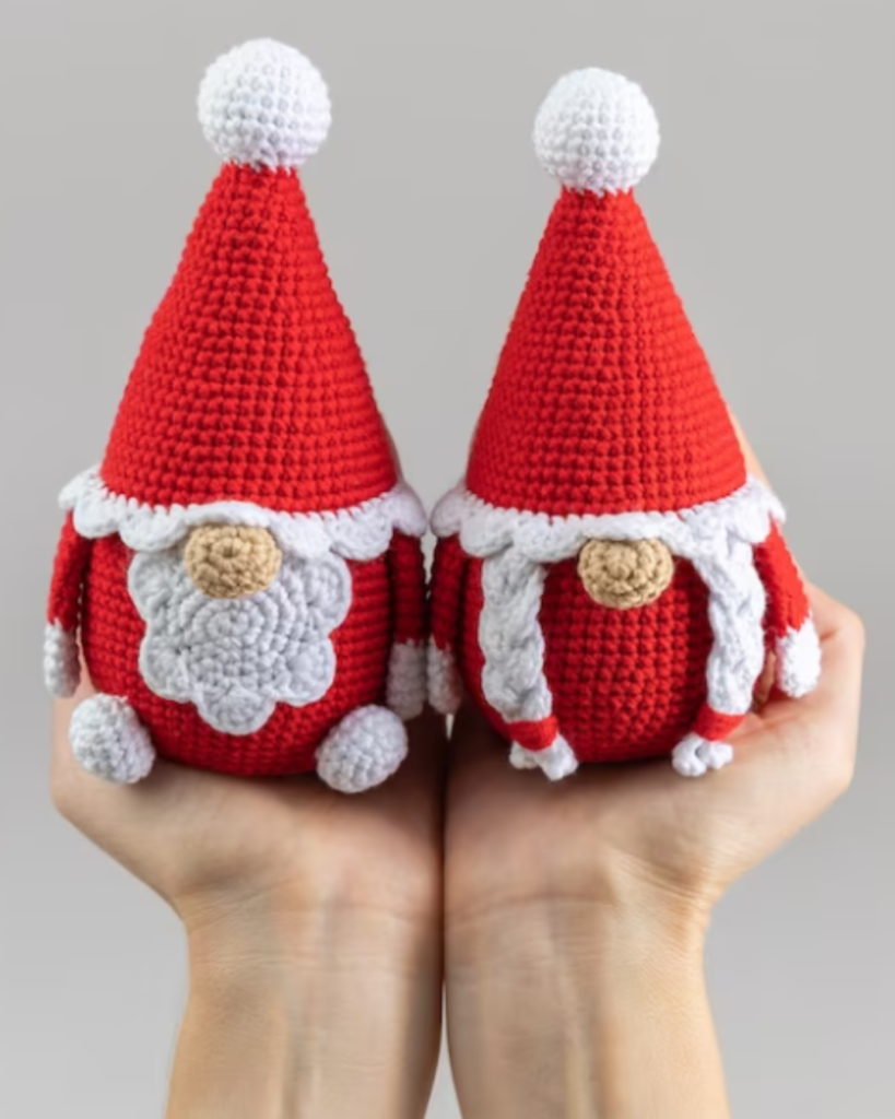 hands holding two crochet mr and mrs claus gnomes