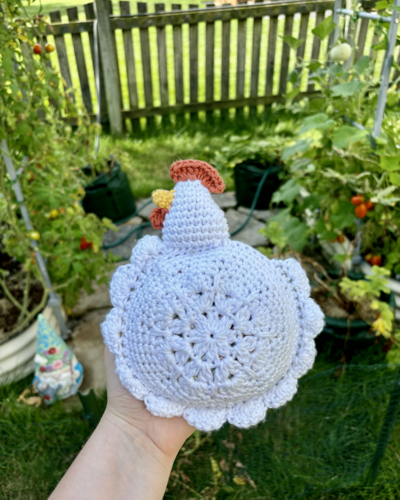hand holding crochet chicken