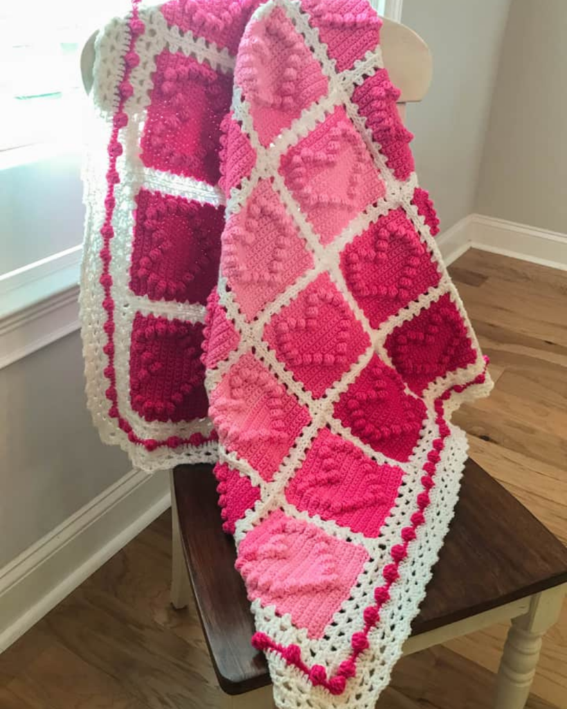 handmade crochet baby blanket draped over chair
