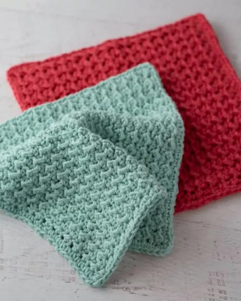 Crochet dishcloth made with textured stitches in red and teal cotton yarn