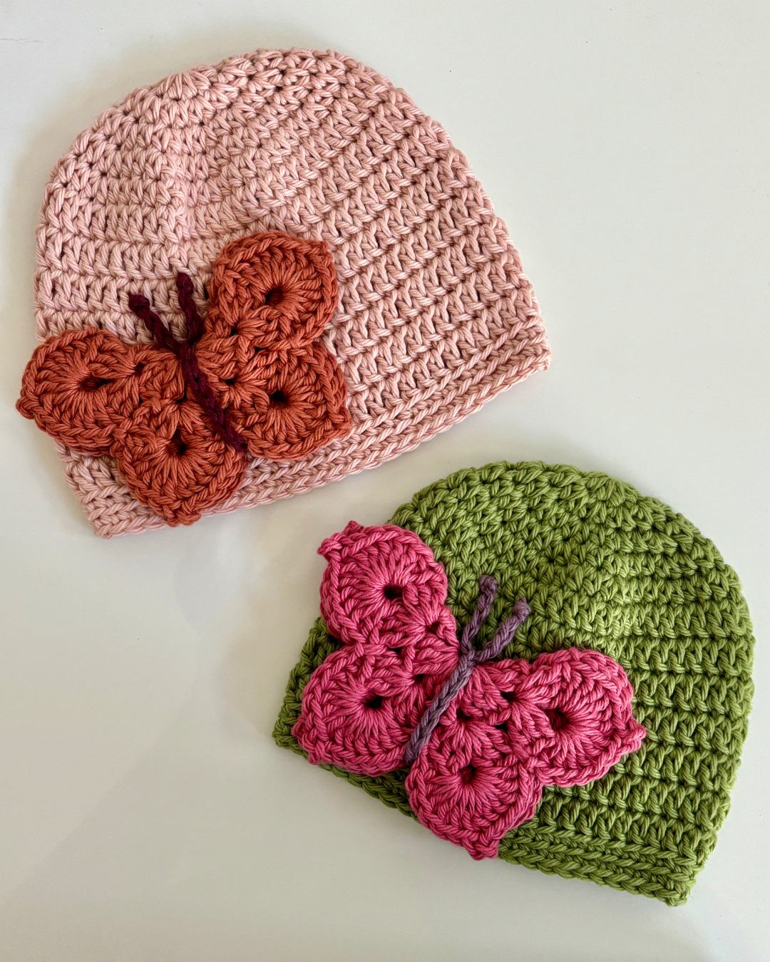 Close-up of Butterfly Kisses crochet baby hat with colorful butterfly applique