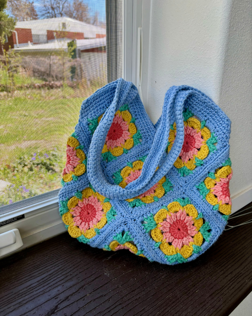 Colorful crochet flower purse bag made with granny square flowers and shoulder strap