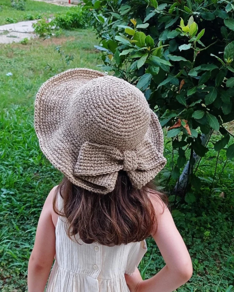 Crochet sun hat featuring a decorative bow and wide brim for summer wear