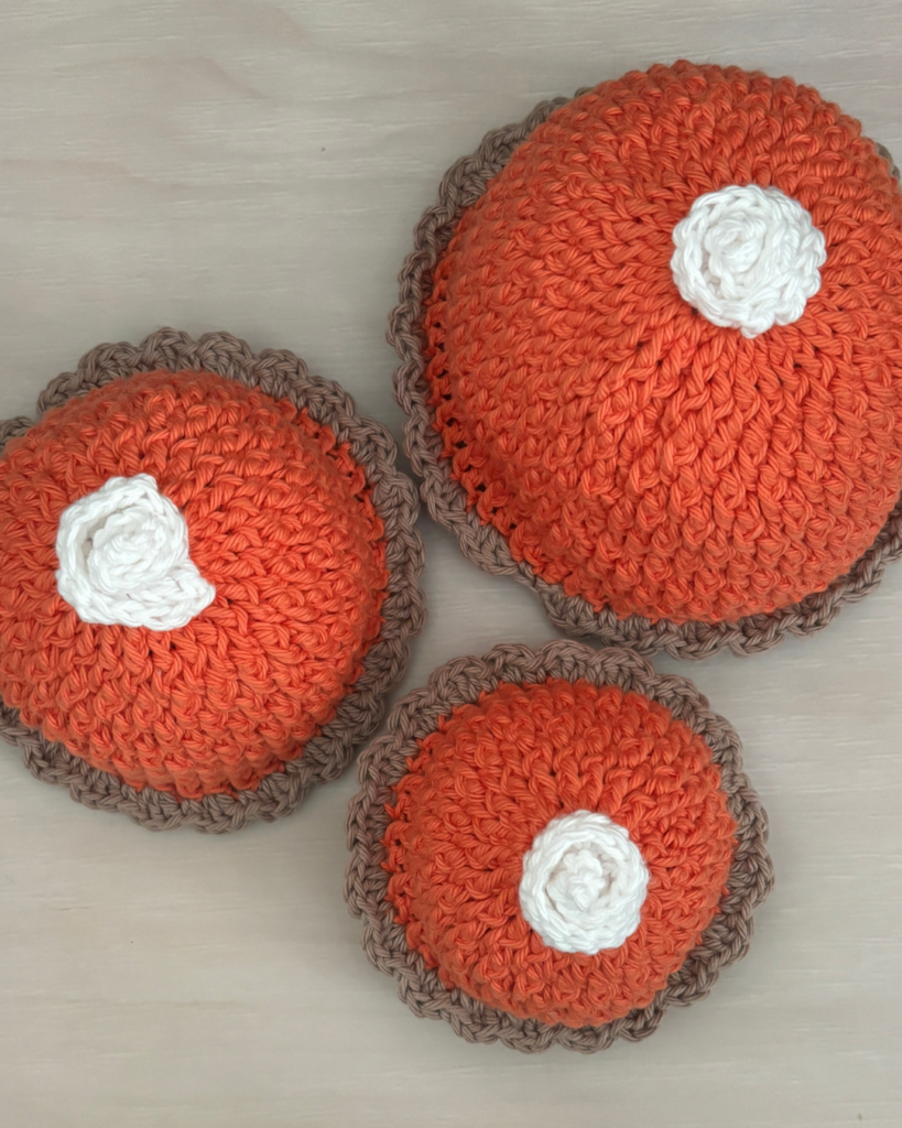 Top view of the crochet Pumpkin Pie Baby Hat with a white whipped cream dollop on top