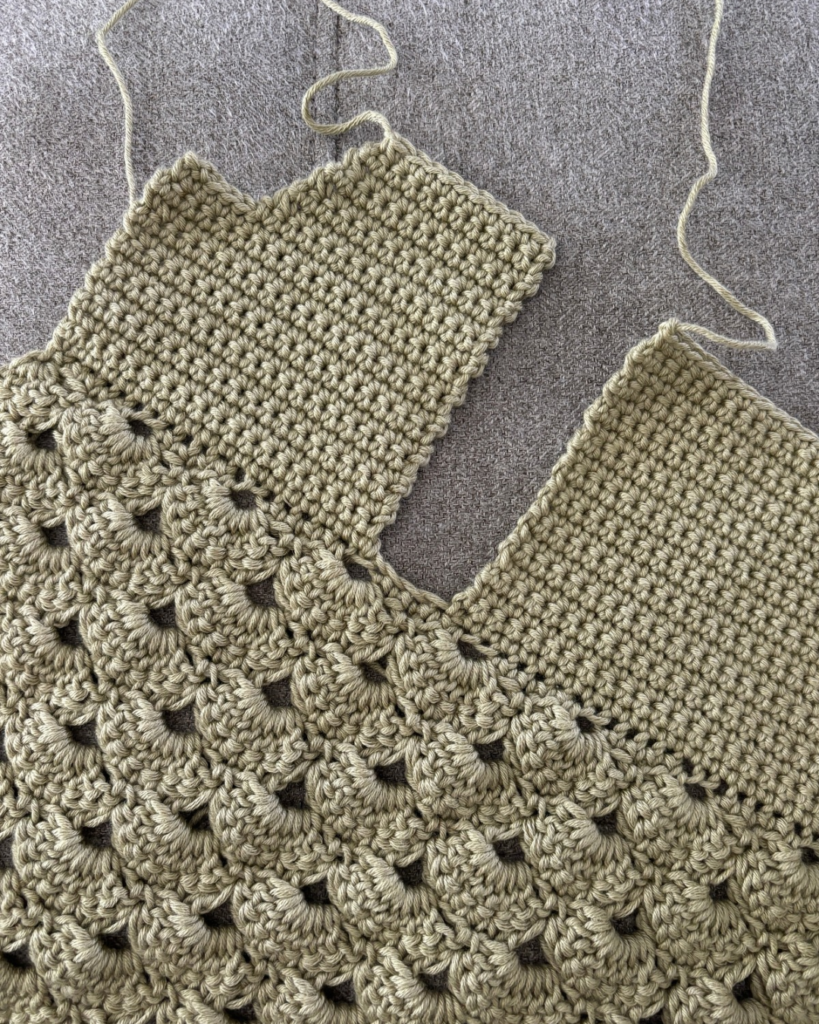 in progress photo of baby cardigan arm opening before shoulder has been sewn