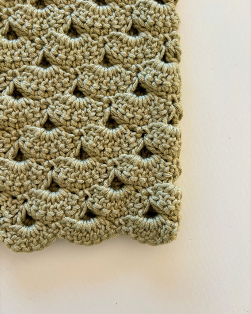 Close-up of the shell stitch texture on the Sweet Pea crochet baby cardigan