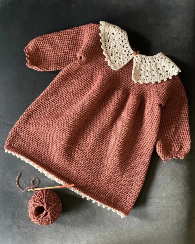 Crochet baby dress with a simple silhouette and delicate lacy collar.