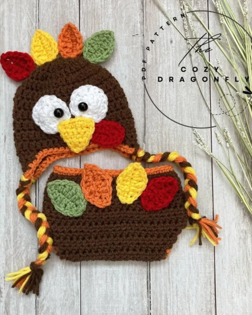 Crochet baby turkey outfit with a turkey hat and colorful feather details on the hat and bloomers.